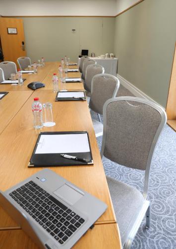 a conference room with a long table with a laptop on it at Ballymascanlon Hotel and Golf Resort in Dundalk
