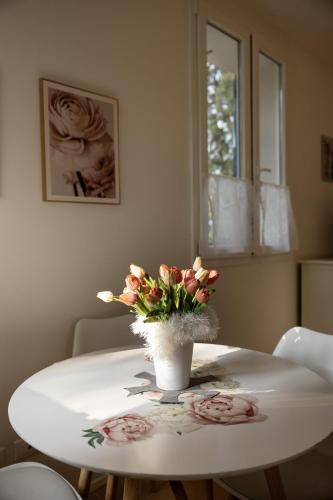 a white table with a vase of flowers on it at B&B Cá Bianca Ventisette Riccione in Riccione