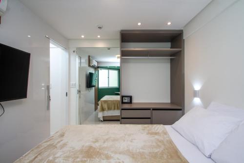 a bedroom with a large bed and a television at Edif Flat Beira Mar in Recife