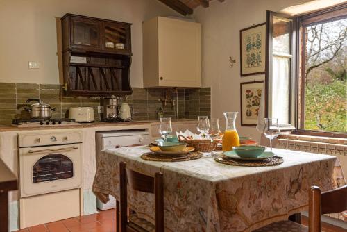 a kitchen with a table with plates and glasses on it at Podere Colombaio - Verbena in Radicofani