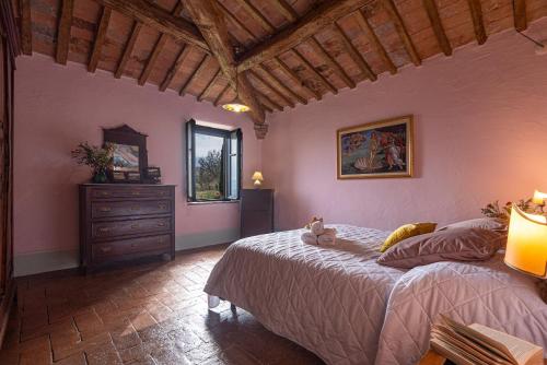 a bedroom with a bed with a cat sitting on it at Podere Colombaio - Verbena in Radicofani