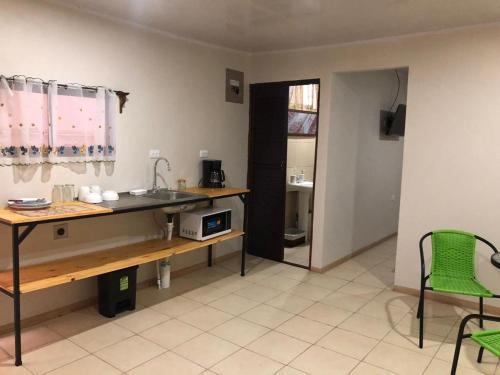 Santiago Este的住宿－Rivera Family Apartments，厨房配有水槽和桌椅