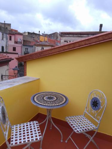 two chairs and a table on a balcony at Piccola Casa Di Sardegna in Villanova Monteleone