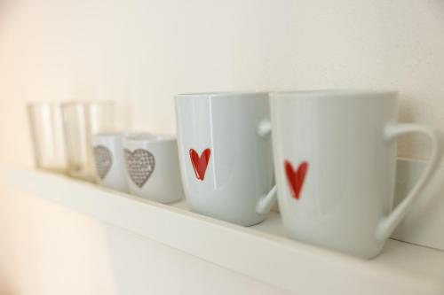 four coffee cups on a shelf with hearts on them at B&B Cá Bianca Ventisette Riccione in Riccione
