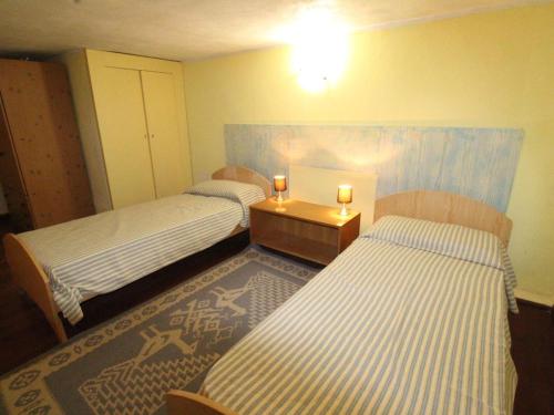 a room with two beds and a table with two candles at 4-room apartment Tanca Manna, only 300 meters from the beach in Cannigione