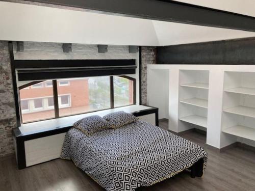 um quarto com uma cama e uma grande janela em Arts Urban duplex Loft & RoofTop em Roubaix