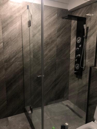 a shower with a glass door in a bathroom at Lumandi LS residence in Mamaia Nord