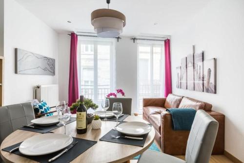 une salle à manger avec une table et un canapé dans l'établissement EasyLodge - Appartement 3 chambres Bordeaux, à Bordeaux