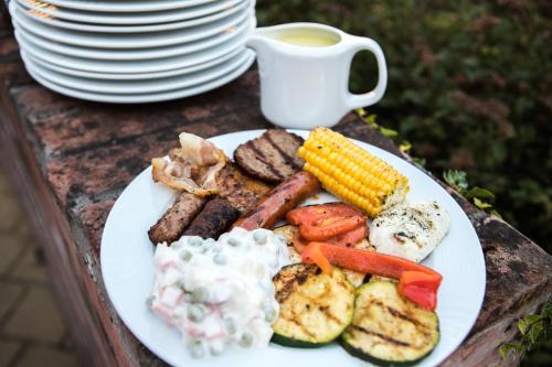 a plate of food with meat and vegetables and a cup of coffee at Pelso Panzio in Balatonmáriafürdő