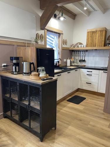 a kitchen with white cabinets and a black island at Wioska w Sowich Sokolec in Sokolec