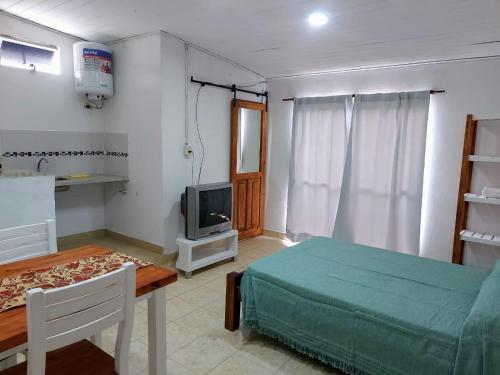 Habitación con cama, mesa y TV. en Laprida2 en Curuzú Cuatiá