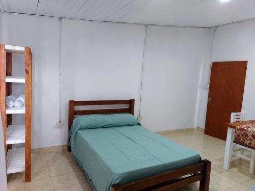 1 dormitorio con 1 cama con edredón verde en Laprida2 en Curuzú Cuatiá