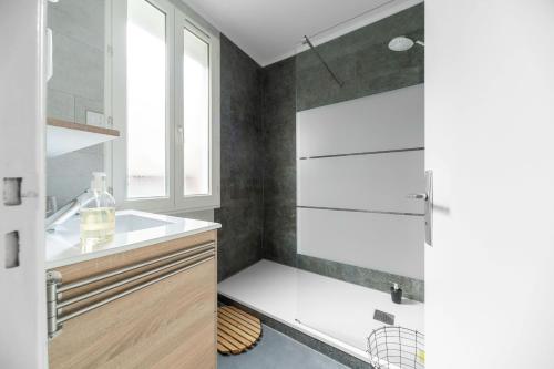 a bathroom with a sink and a shower at L'Annexe Gannat - Appartements en centre ville in Gannat