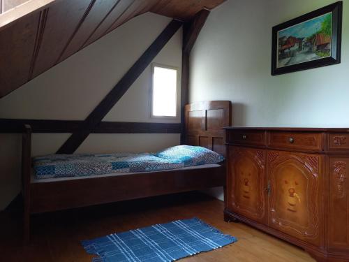 een slaapkamer met een bed en een houten dressoir bij Vila Liduška 