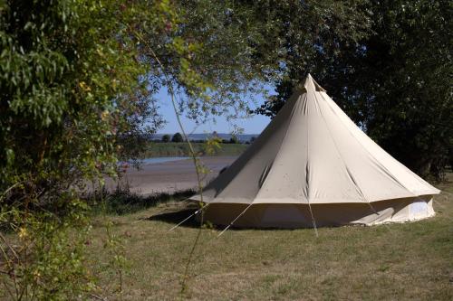 Westbury on Severn的住宿－Rivers View Holidays，坐在路边草上的白色帐篷