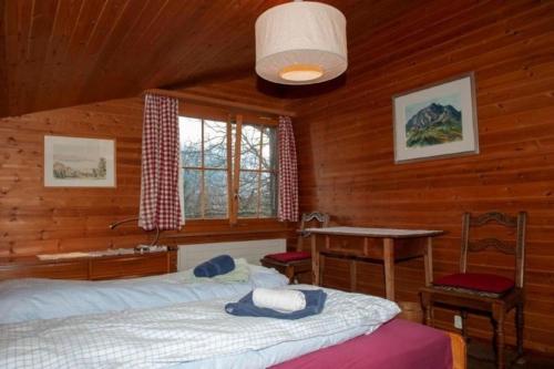 a bedroom with two beds and a desk in a cabin at Ferienhaus Roth Flüehli, Hasliberg Goldern, 5-Bettwohnung in Hasliberg