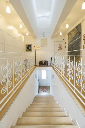 a staircase in a house with white walls and wooden railings at B&B Cá Bianca Ventisette Riccione in Riccione