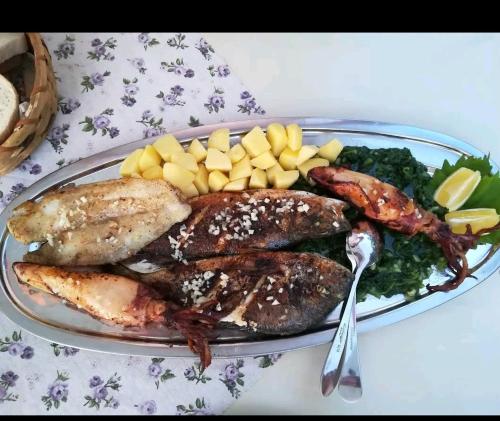 a plate of food with fish and vegetables on a table at Matteo in Supetarska Draga
