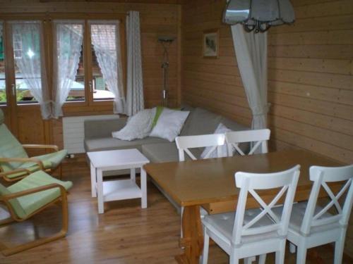 een woonkamer met een bank en een tafel en stoelen bij Ferienwohnung "Margrit Ost" in Lauterbrunnen