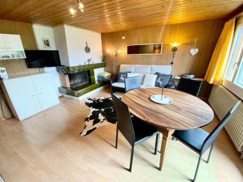 uma cozinha e sala de estar com uma mesa de madeira e cadeiras em Bärengaden 4-Bettwohnung em Hasliberg Wasserwendi