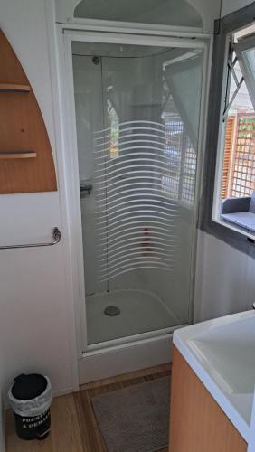uma cabina de duche em vidro na casa de banho com um lavatório em Makado em Castillon-en-Couserans