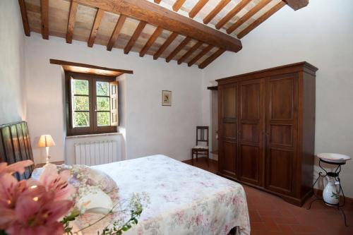 a bedroom with a bed and a wooden cabinet at Pilari Intera struttura in Corgna