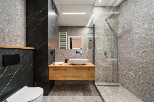 een badkamer met een wastafel en een douche bij Krakowiak Apartment in Krakau