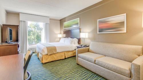 Habitación de hotel con cama y sofá en Holiday Inn Express Hotel & Suites Midlothian Turnpike, an IHG Hotel, en Richmond