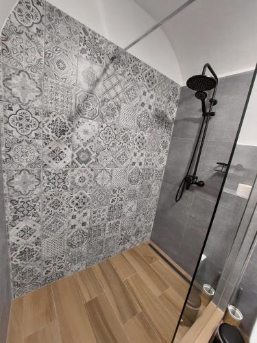 a bathroom with a shower with a tile wall at Villa Celnice in Český Krumlov