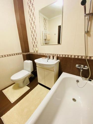 a bathroom with a tub and a toilet and a sink at Центр (2). Простора квартира. С. Крушельницької in Ternopil