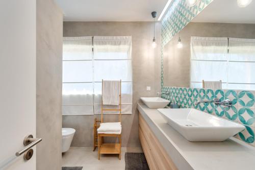 uma casa de banho com 2 lavatórios e um WC em Garden Seaside Villa by CadenzaLux em Cascais