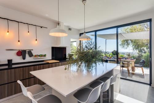 uma cozinha com uma grande mesa branca e cadeiras em Garden Seaside Villa by CadenzaLux em Cascais