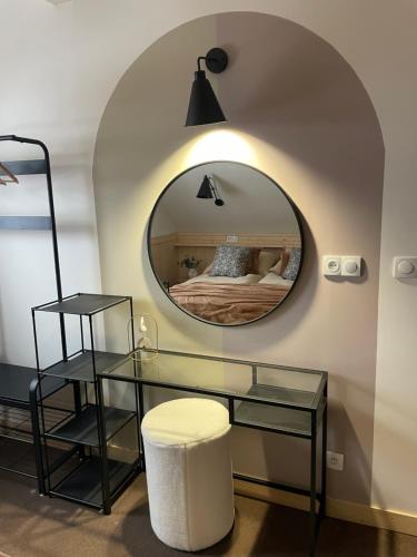 a mirror in a room with a bed and a stool at Wioska w Sowich Sokolec in Sokolec