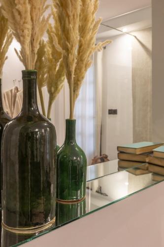 two green vases sitting on a counter in front of a mirror at Riad Ksar Saad & Spa in Marrakech
