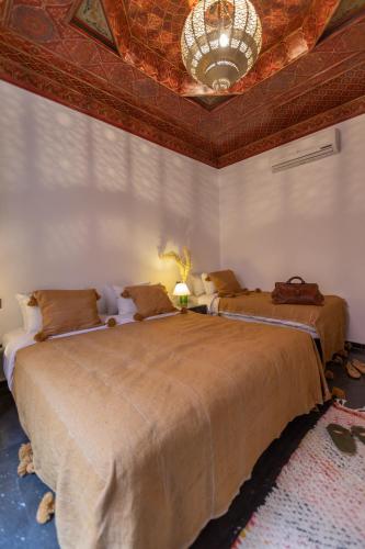 a bedroom with two large beds with a ceiling at Riad Ksar Saad & Spa in Marrakech