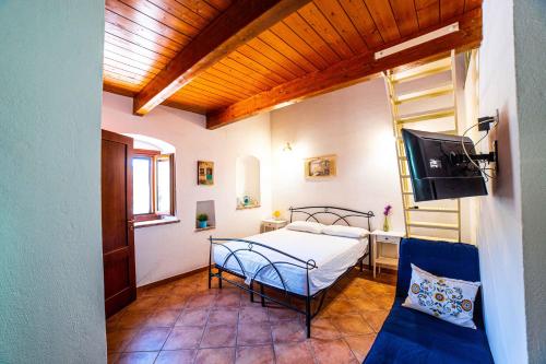 ein Schlafzimmer mit einem Bett, einem TV und einem Sofa in der Unterkunft La Mantecata b&b in Itri