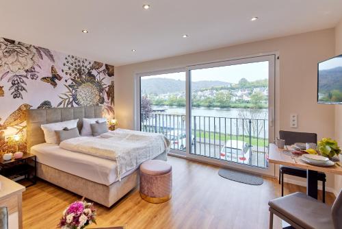 een slaapkamer met een bed en een groot raam bij Luxus Apartments Mosel-Zeit NEU 2023 in Zell an der Mosel