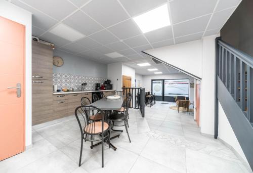 a dining room and kitchen with a table and chairs at L'Annexe Gannat - Appartements en centre ville in Gannat