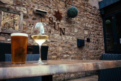 a glass of wine and a glass of beer on a table at The Sun Hotel & Bar in Lancaster