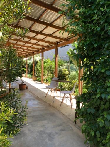 a wooden pergola with a table and chairs under it at Urban Plett in Plettenberg Bay