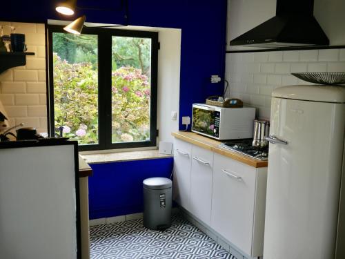 une cuisine avec un réfrigérateur blanc et une fenêtre dans l'établissement Nature, Mer, Golf & Decouvertes..., à Plouha