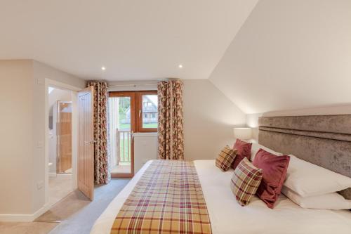 a bedroom with a king sized bed with colorful pillows at Lord Galloway 39 with Hot Tub in Newton Stewart