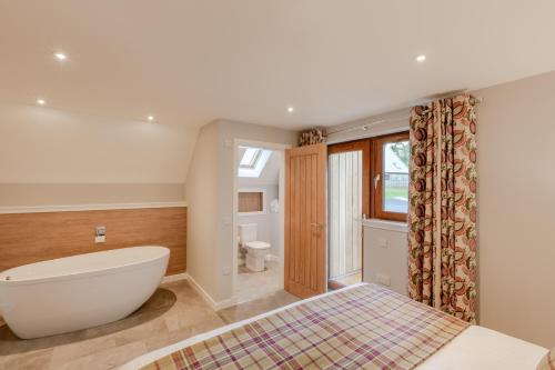 a bedroom with a bath tub and a toilet at Lord Galloway 39 with Hot Tub in Newton Stewart