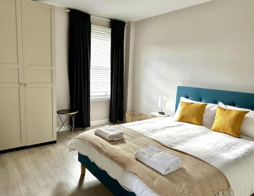 a bedroom with a large bed with a blue headboard at Sienna's 2 - bedroom apartment, London, N1. in London
