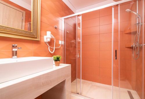 een badkamer met een glazen douche en een wastafel bij Astarte Villas - Ocean Pool Villa in Tsilivi