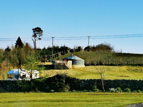 a field with a couple of domes on a hill at The Yurt in Newton Stewart
