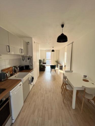 uma cozinha com uma mesa e uma sala de jantar em Modern and bright apartment near Paris em La Courneuve
