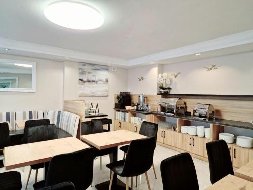 restauracja ze stołami i krzesłami oraz kuchnia w obiekcie Villa Cristal w Świnoujściu