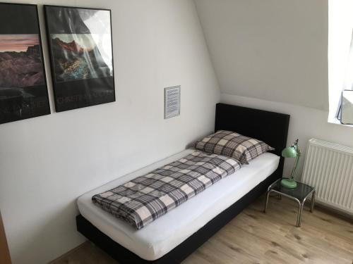 een kleine slaapkamer met een bed met een geruite deken bij Op Nijverdal in Nijverdal