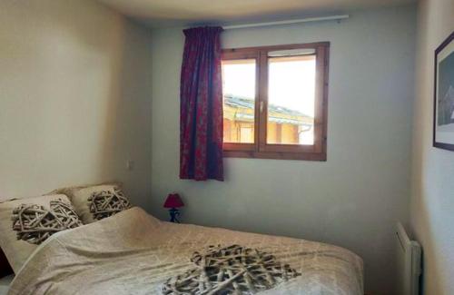 a bedroom with a bed and a window at Chalet de 4 chambres a Valmeinier a 500 m des pistes avec piscine partagee sauna et balcon in Valmeinier